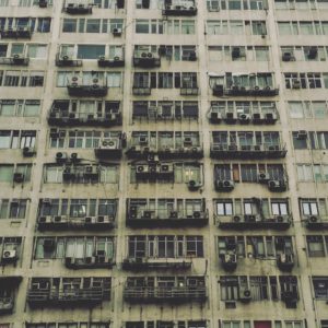 alt text: image is a color photograph of a run-down apartment complex; title card for the short story "And a Single Day" by Randy William Santiago