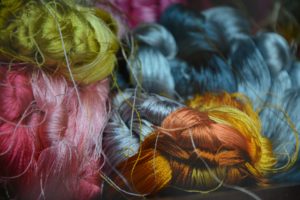 alt text: image is a color photograph of tangled thread; title card for the craft essay "In the Expanded Field: The Lyric Essay & Genre Queerness" by Katy Scarlett
