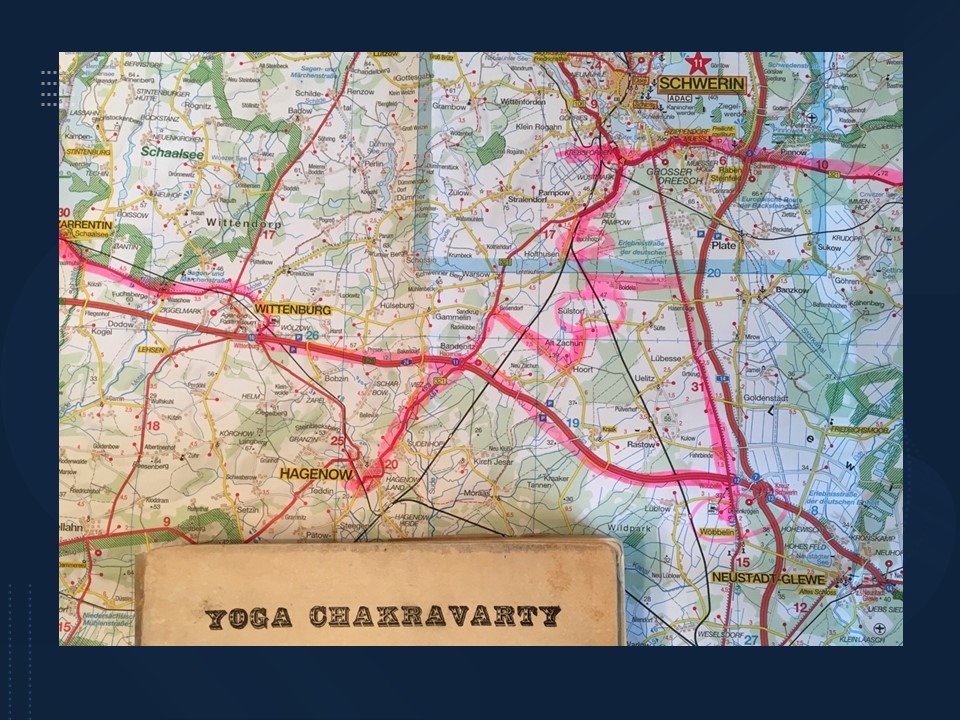 Slide 11 A map of Germany with many pink and red lines. The rim of an old book with the title YOGA CHAKRAVARTY. Alt-text: Marco Polo map, Mecklenburg-Vorpommern and Yoga Chakravarty, by Sri Harry Dickman