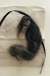 Image shows a lock of hair with the handwritten caption: "Leslie June 13."