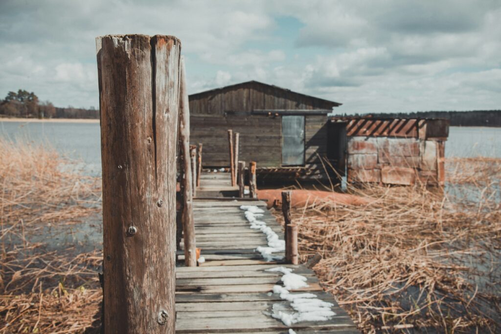Image is a color photograph of a bridge on water; title card for the new short story, "because if something no right, you no suppose sit down and look," by Ayotola Tehingbola.